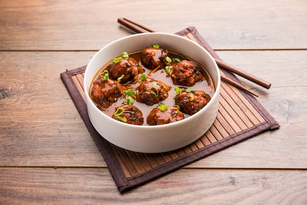 Verduras o pollo manchuriano con salsa - Comida popular de la India servida en un tazón con palillos