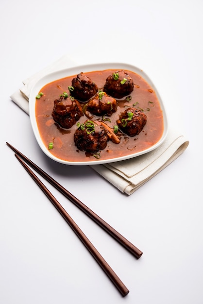 Verduras o pollo manchuriano con salsa - Comida popular de la India servida en un tazón con palillos