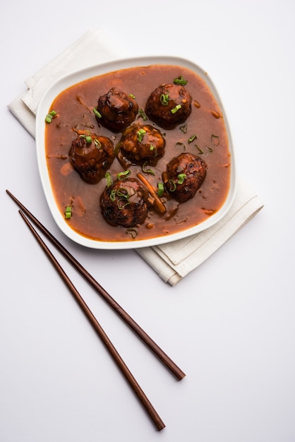 Verduras o pollo manchuriano con salsa - Comida popular de la India servida en un tazón con palillos