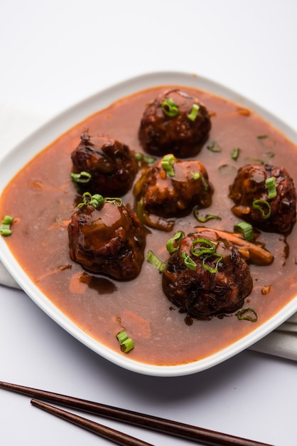 Verduras o pollo manchuriano con salsa - Comida popular de la India servida en un tazón con palillos