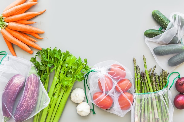 Verduras orgánicas frescas en bolsas de compras de productos ecológicos reutilizables endecha plana, vista superior