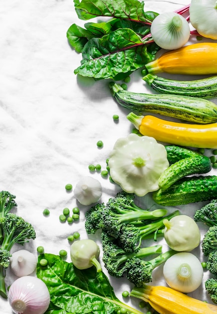 Verduras orgánicas frescas calabacín calabaza pepinos brócoli cebollas ajo acelga guisantes verdes sobre un fondo claro vista superior Dieta de estilo de vida saludable