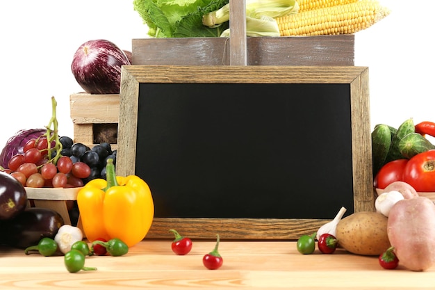 Verduras orgánicas frescas con pizarra en la mesa de madera de cerca