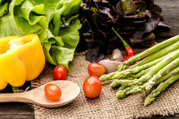 verduras orgánicas frescas, tomates, espárragos, ensalada, chile en cilicio en la cocina.