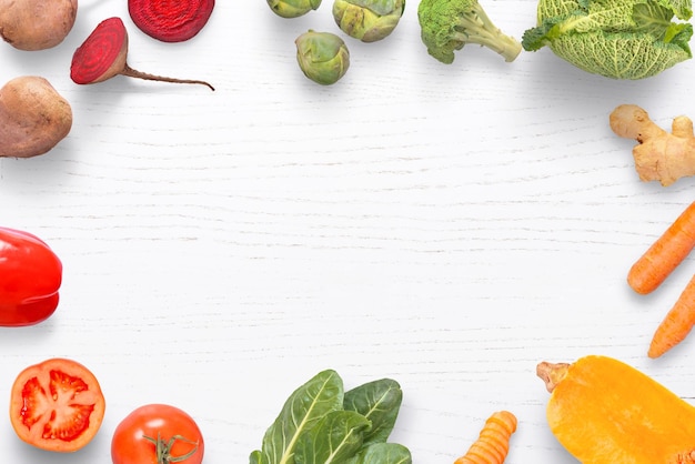 Foto verduras orgánicas naturales en una mesa de cocina blanca con espacio para agregar texto