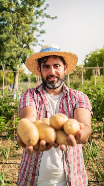 Verduras orgánicas Patatas frescas en manos de un agricultor Hombre alegre