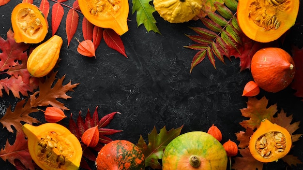 Verduras de otoño Calabaza con semillas de calabaza y hojas de otoño sobre un fondo de piedra negra Vista superior Espacio libre para el texto