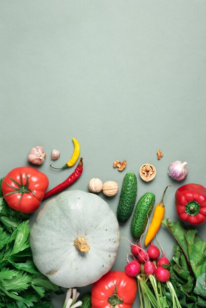 Verduras de otoño sobre fondo verde Vista superior Concepto de cosecha de dieta vegana y vegetariana Ingredientes para cocinar calabaza tomates pepino pimienta remolacha apio ajo rábano