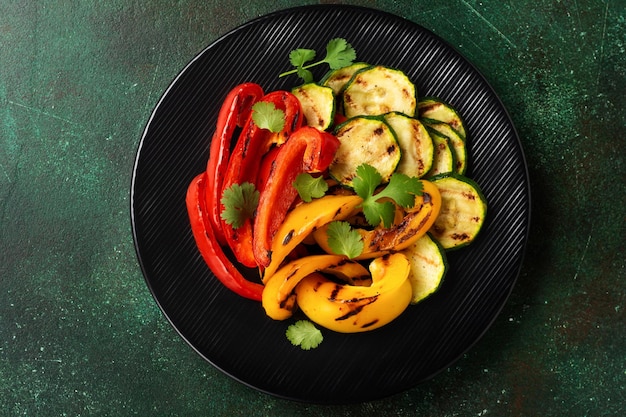 Verduras a la parrilla calabacín pimiento rojo y amarillo pimiento y ramo de cilantro en una sartén a la parrilla Vista superior Concepto de barbacoa