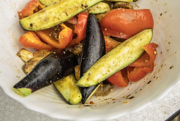 Verduras a la parrilla pimientos calabacín berenjenas en un plato blanco vista de arriba de cerca