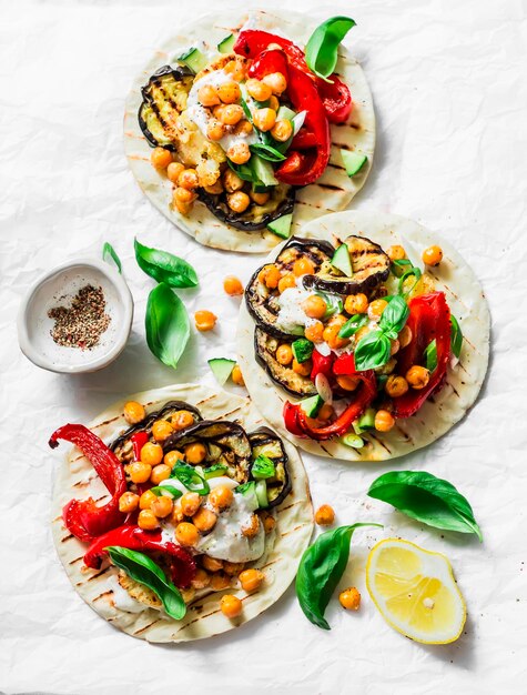 Verduras a la parrilla de verano y tortillas vegetarianas de garbanzos picantes sobre un fondo claro