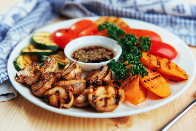 Verduras a la plancha con salsa en una mesa de madera