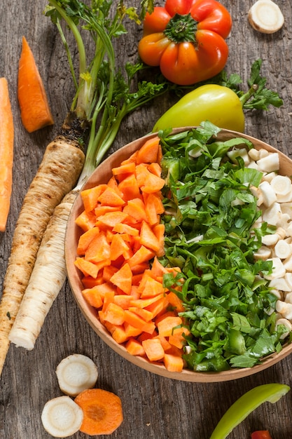 Verduras en un recipiente en la mesa de madera