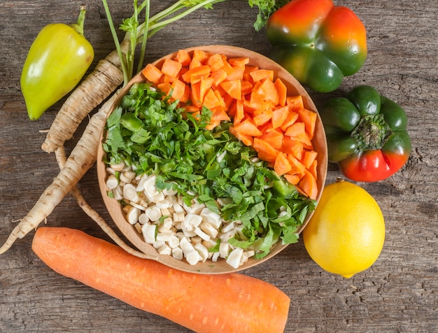 Verduras en un recipiente en la mesa de madera