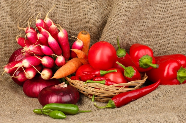 Verduras rojas frescas sobre fondo de tela de saco