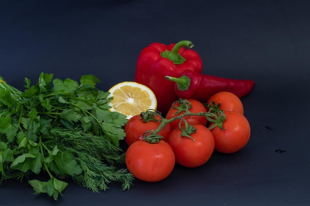 Verduras rojas sobre fondo negro Pimientos y tomates ajo