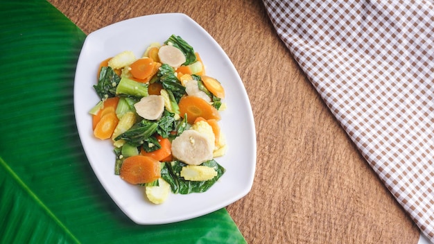 Verduras salteadas calientes en un plato blanco Enfoque selectivo del concepto de comida asiática saludable