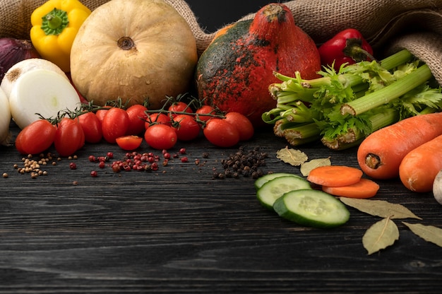 Verduras sobre un fondo de madera oscura, bellamente decorado bodegón de verduras.