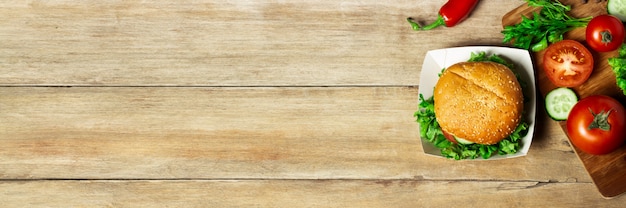 Verduras en una tabla de cortar sobre un fondo de madera. Productos para cocinar. Copia espacio Banner