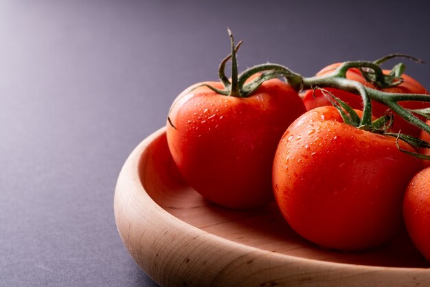 Verduras de tomate en placa de madera de cerca, ángulo de visión