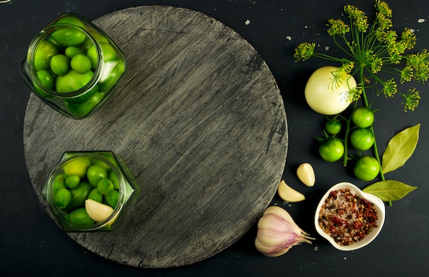 Verduras verdes, especias y bandeja de madera.