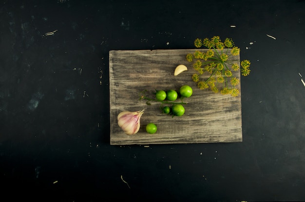 Verduras verdes y especias en tabla de cortar de madera