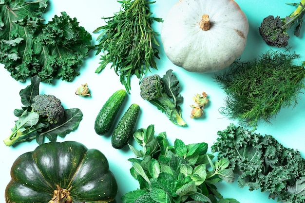 Verduras verdes frescas sobre fondo de menta de moda Vista superior Espacio de copia Comer alimentos alcalinos limpios Dieta vegana y vegetariana