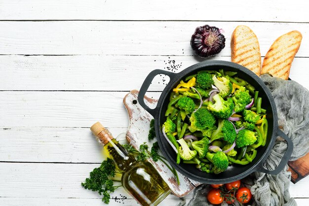 Verduras verdes guisadas en una sartén Frijoles de brócoli Guisantes verdes Vista superior Espacio libre para su texto