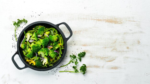 Verduras verdes guisadas en una sartén Frijoles de brócoli Guisantes verdes Vista superior Espacio libre para su texto