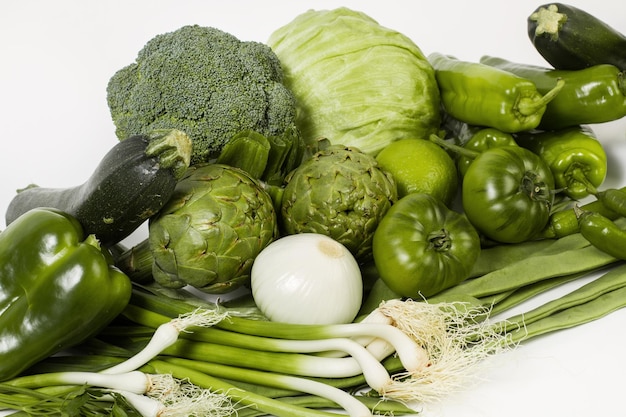 Verduras verdes sobre un fondo blanco de madera