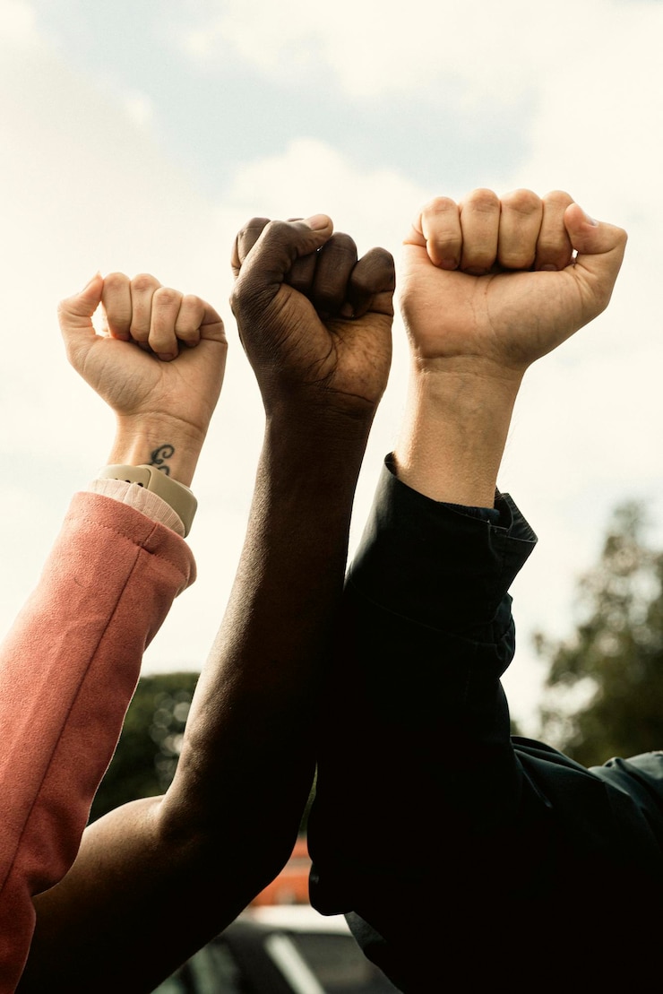 Foto vereinigte fäuste in solidarität gegen einen bewölkten himmel