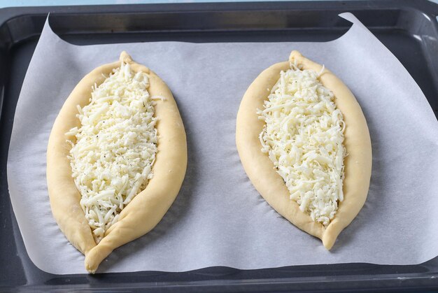 Verfahren zum Kochen georgischer Khachapuri mit Käsepasteten in Form eines Bootes werden mit Käse gefüllt und auf einem Backblech ausgelegt Schritt für Schritt Anleitung Schritt 3