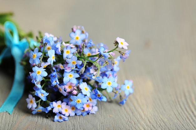 Vergissmeinnicht-Blumen auf Holzuntergrund