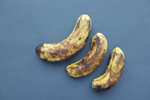 Vergleiche eine faule Banane mit einer reifen Banane auf einem weißen Hintergrund