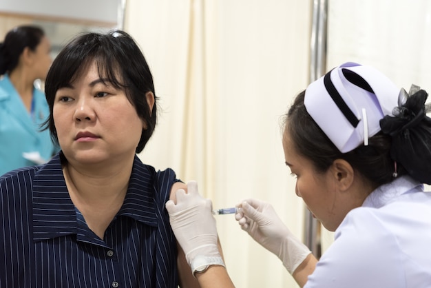 Verificação de saúde da mulher asiática por vacinado