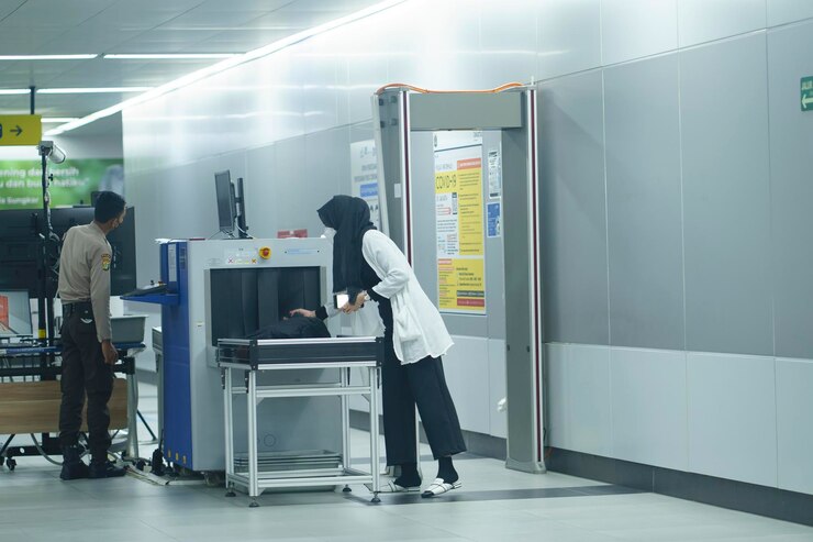 Foto verificação de segurança na estação mrt jakarta indonésia com policial masculino e passageira em 20 de abril de 2023