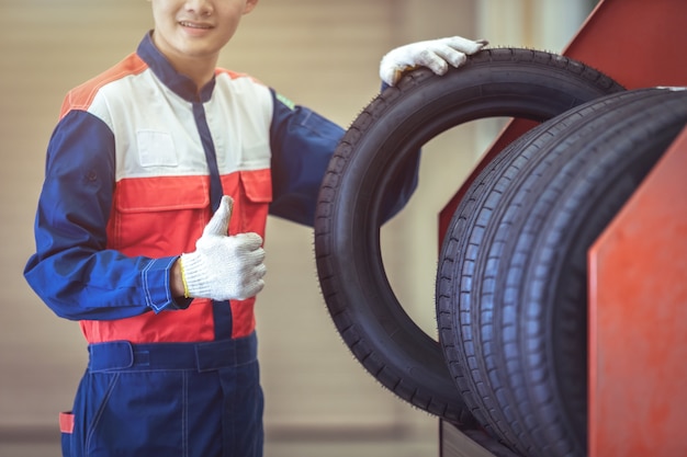 Verificando novos pneus padrão no grande armazém no centro de serviço de reparo de automóveis