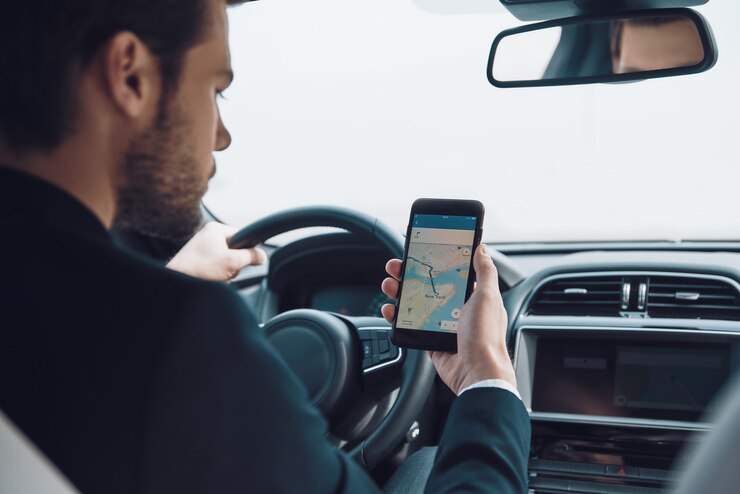 Foto verificando o caminho certo. vista traseira de um jovem usando um telefone inteligente para verificar o mapa enquanto dirige um carro