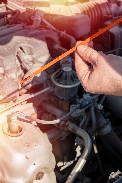 Foto verificando o nível de óleo do motor. mão do mestre segura o calibrador de folga