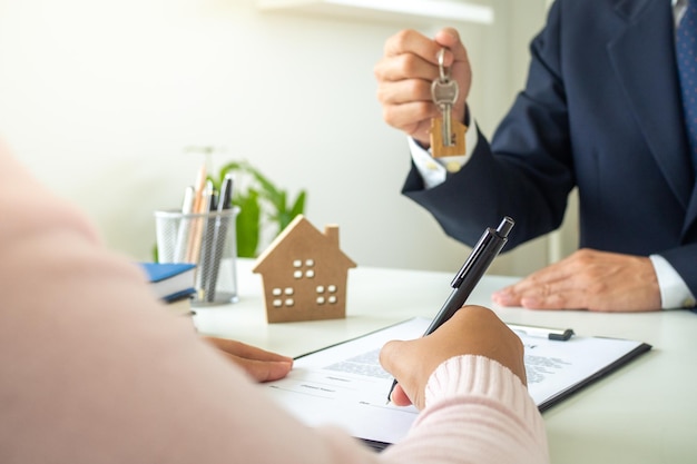 Verkäufer oder Vermieter geben dem Kunden die Hausschlüssel, der Kunde unterschreibt den Hypothekendarlehensvertrag. Kaufen verkaufen Haus mieten