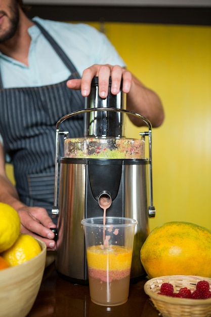 Verkäuferin bereitet Fruchtsaft zu