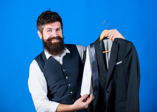 Foto verkäuferin oder persönlicher stylist-service passendes krawatten-outfit mann bärtige hipster halten krawatten und formellen anzug perfekte krawatte shopping-konzept stylist-beratung schwierigkeiten bei der auswahl der krawatte