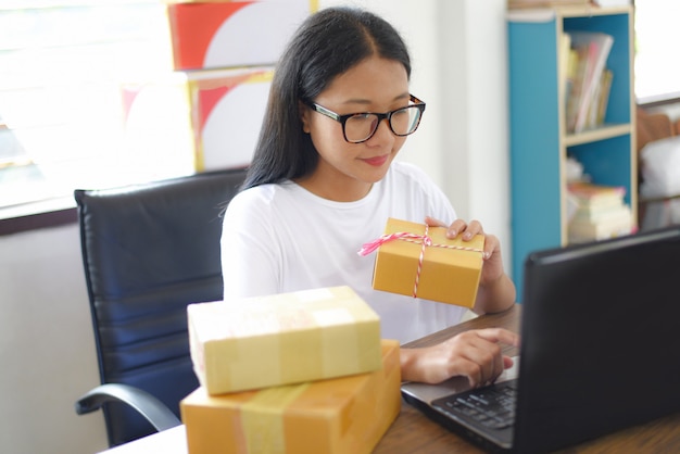 Verkauf des Online-E-Commerce-Versands des Online-Shoppings und des Arbeitskonzeptes des Kleinunternehmers des Bestellungsstarts - Verpackungspappschachtelpaketlieferung der jungen Frau zur Kundennachnahme