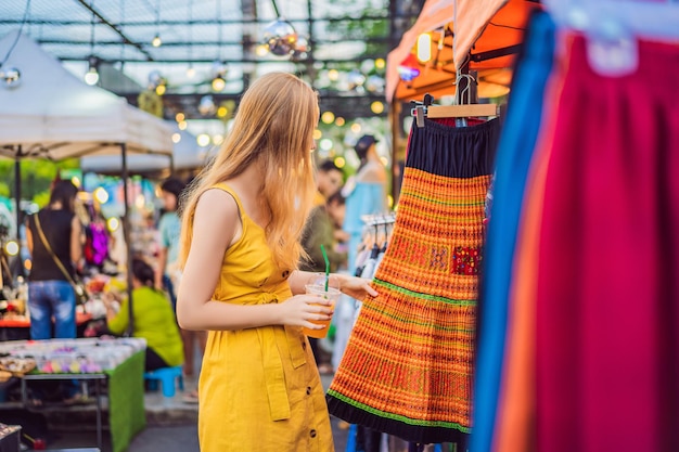 Verkauf im Einzelhandel und Bekleidungskonzept Frau wählt Kleidung auf dem asiatischen Markt