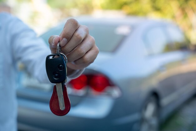 Foto verkauf von autos autoverkaufsangebot mieten sie ein auto für ausländische touristen konzept der händler gibt die autoschlüssel an den neuen besitzer oder mieter mit einem versicherungsvertrag