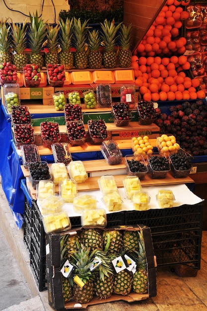 Verkauf von Obst auf der Straße. Obstgeschäft. Ananas und Kirschen in Kisten.