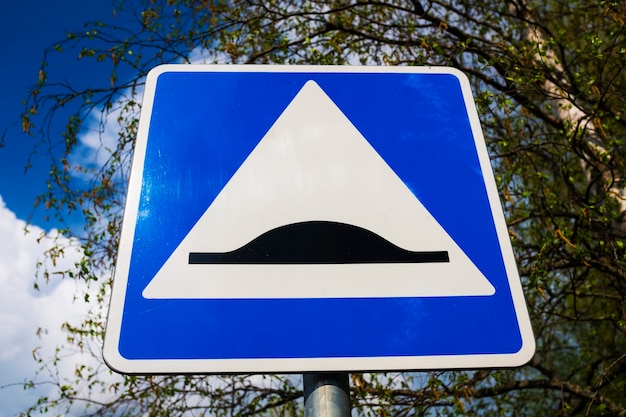 Verkehrszeichen-Geschwindigkeitsschwelle. blaues Quadrat mit weißem Dreieck und schwarzem Hindernis. Foto in hoher Qualität