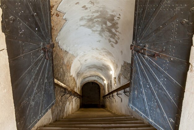 Verlassene alte Treppe mit gebrochenen Wänden zu einem Keller einer alten Festung