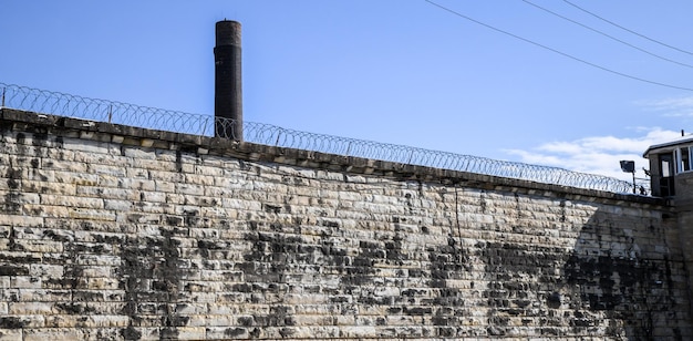 Foto verlassene gefängnismauer ziegelstein und blauer himmel