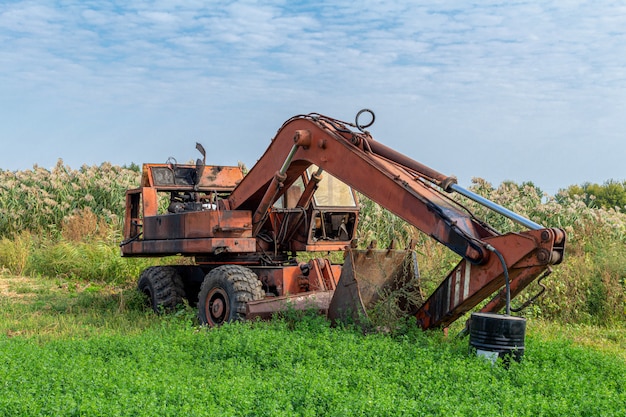 Verlassener gebrochener alter rostiger Bagger. Vergessene Technik.